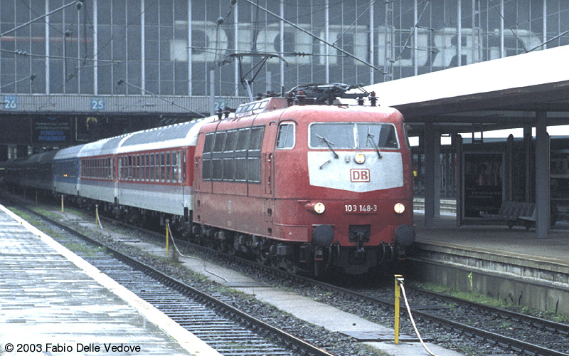 Abfahrt von 103 148-3 mit dem IR 2120 SPESSART nach Würzburg um 16:29 Uhr von Gleis 25 bei strömendem Regen (München Hauptbahnhof, April 2001).