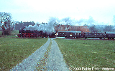 Zum Vergrößern klicken - Bemerkenswerte Übereinstimmung zwischen dem Verkehrszeichn vor dem unbeschrankten Bahnübergang und dem vorbeifahrenden Zug (Mennisweiler, 06. April 2003).