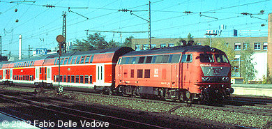 Die orientrote 218 444-8 vor einem verkehrsroten Dosto-Zug nach Mühldorf (München Heimeranplatz, Oktober 2001)