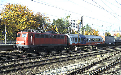 Um 10:33 Uhr fährt eine "Rollende Landstraße" durch. Die 139 250-5 gibt sich ganz modern in verkehrsrot und mit Einholmstromabnehmern (München Heimeranplatz, Oktober 2002).