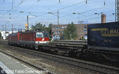 182 011-7 hat 1044 238-2 und einen Zug aus Einheitstaschenwagen im Schlepp, als sie um 11:05 Uhr in Richtung Laim unterwegs ist (München Heimeranplatz, Oktober 2002).