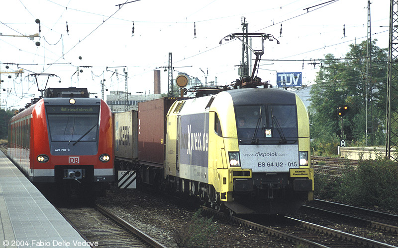 Links hält gerade 423 710-3 bzw. S 8336 (Pasing 16:36 - Heimeranplatz 16:42 - Höllriegelskreuth 16:56), rechts fährt der boxXpress mit ES 64 U2 - 015 in Richtung München Ost vorbei (München Heimeranplatz, September 2003).