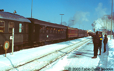 Zum Vergrößern klicken - Die Fahrgäste schauen aus geöffneten Fenstern, die Eisenbahnfreunde auf dem Bahnsteig fotografieren und winken (Kempten, 15.02.2003).